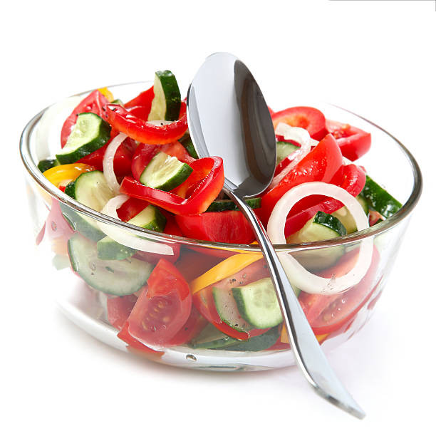 istock Fresh vegetable salad in a glass dish with a spoon. 489686382