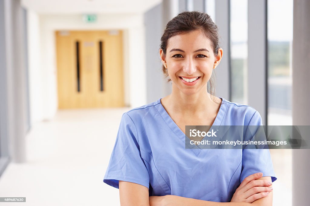 Portrait de femme infirmière, debout dans un couloir de l'hôpital - Photo de Suivi des malades libre de droits