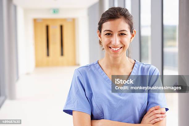 Portrait Of Female Nurse Standing In Hospital Corridor Stock Photo - Download Image Now