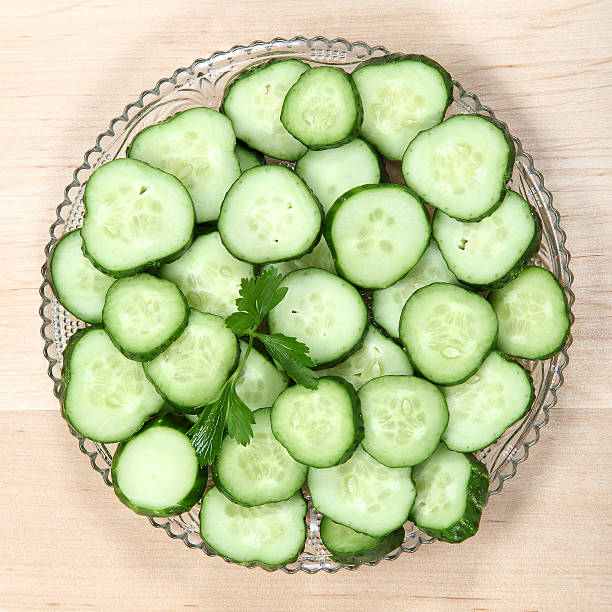 istock Cucumber sliced with fresh herbs on a plate. 489689724