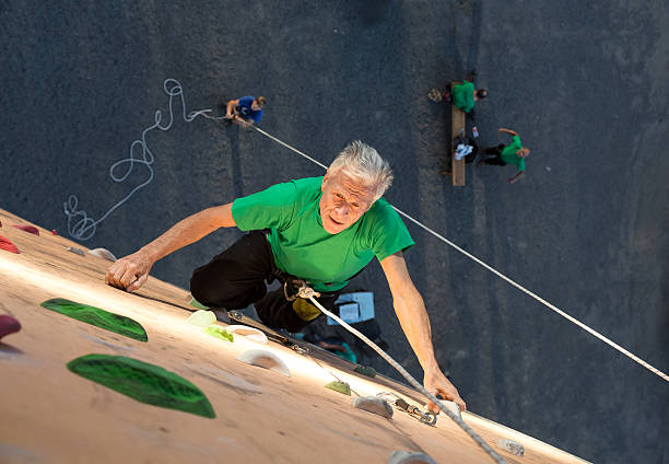 istock Mature Athlete Hanging on Hand and Looking Up 489690536