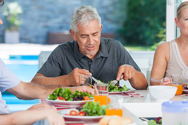 istock senior man with family lunch table 489693117