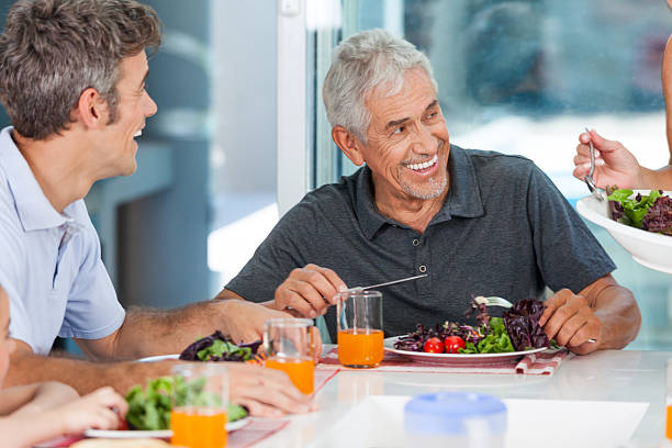 Grandfather and son eat at table