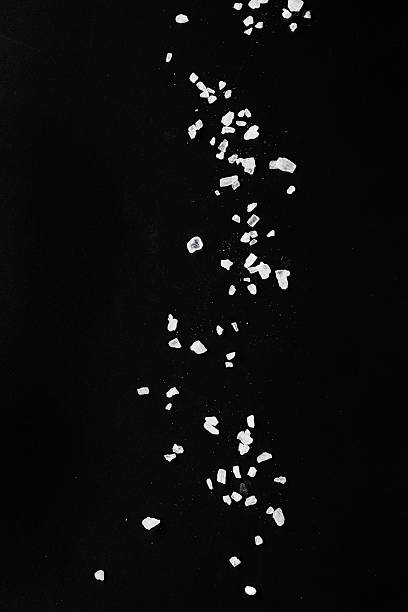 istock Sifting sea salt over black 489694106