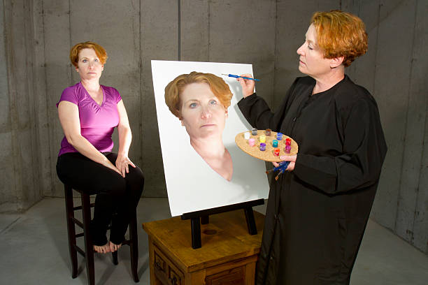 Busy Caucasian lady working next to easel in art studio. Art concept