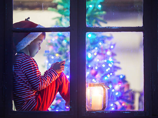 istock Cute boy, sitting on window shield, playing on mobile phone 489697210