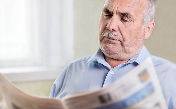 istock Senior Caucasian man reading a newspaper at home 489697327