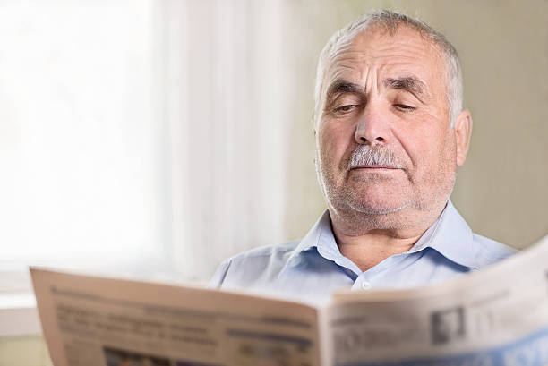 istock Senior Caucasian man reading a newspaper at home 489697359