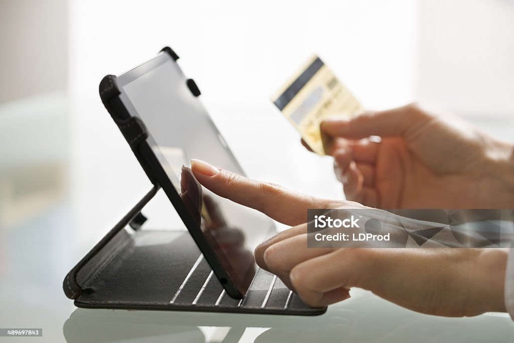 Woman shopping using tablet pc and credit card .indoor.close-up Female computer online order internet Digital Display Stock Photo