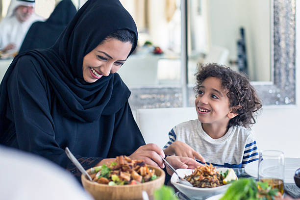 feliz madre y su hijo oriente medio que el almuerzo - women islam middle eastern ethnicity arabic style fotografías e imágenes de stock