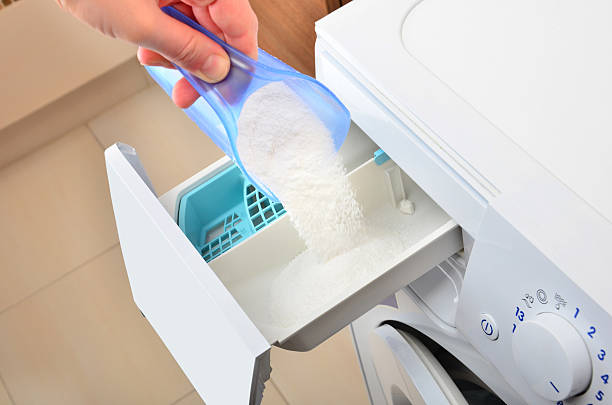 Pouring washing powder Woman hand pouring washing powder into the washing machine laundry detergent stock pictures, royalty-free photos & images