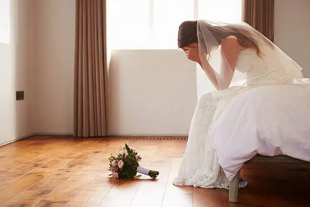 Photo of Bride In Bedroom Having Second Thoughts Before Wedding