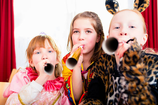 istock Kids with noisemakers making noise on party 489728612