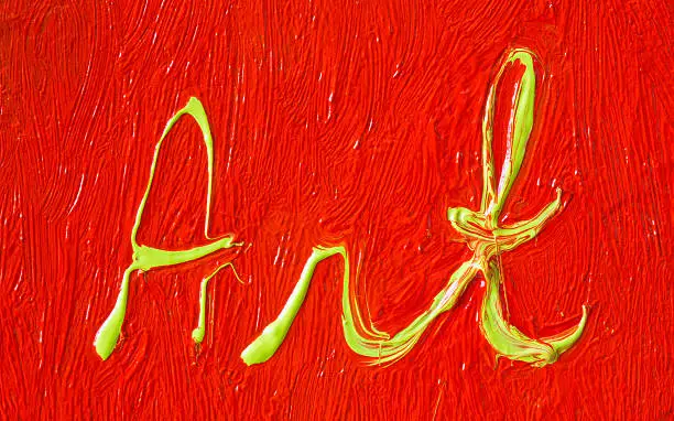 The word art written with yellow oilpaint on red