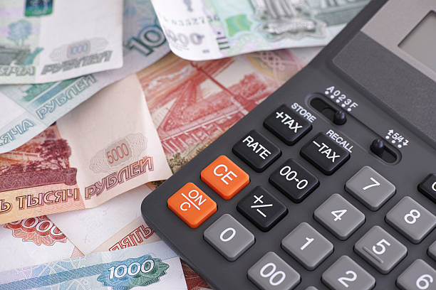 Russian ruble banknotes and calculator Russian ruble banknotes and calculator. Close up. bringing home the bacon stock pictures, royalty-free photos & images