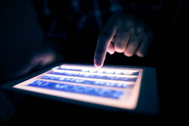 tablet use in the dark stock photo