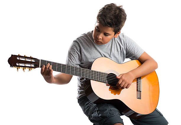 niño tocando la guitarra - plucking an instrument fotografías e imágenes de stock