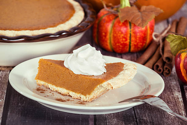 istock Slice of a pumpkin pie on wooden table 489754360