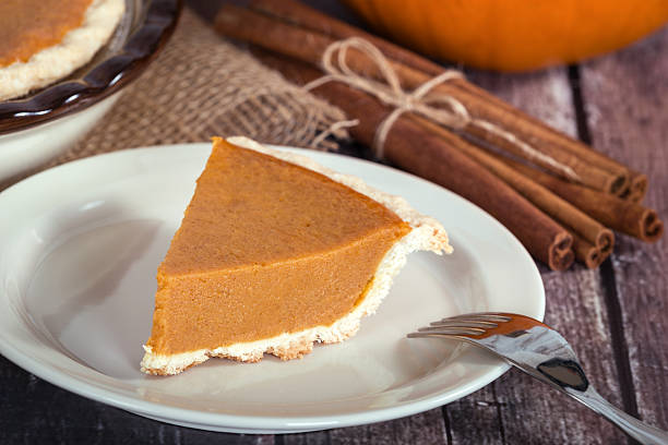 istock Slice of a pumpkin pie on wooden table 489754450