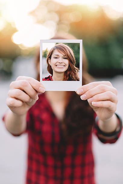 istock Girl holding instant photo 489756328