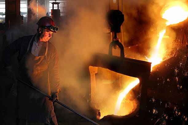 Hard work in the foundry Hard work in the foundry, worker controlling iron smelting in furnaces, too hot and smoky working environment founder photos stock pictures, royalty-free photos & images