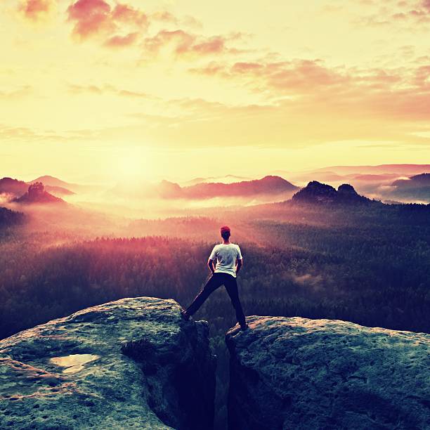istock Crazy jumping hiker in black celebrate triumph between two rocks 489760700
