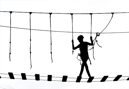 black silhouette of the girl against the sky in a rope park