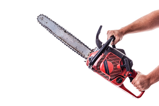 a red chainsaw holded by male arms isolated over white background