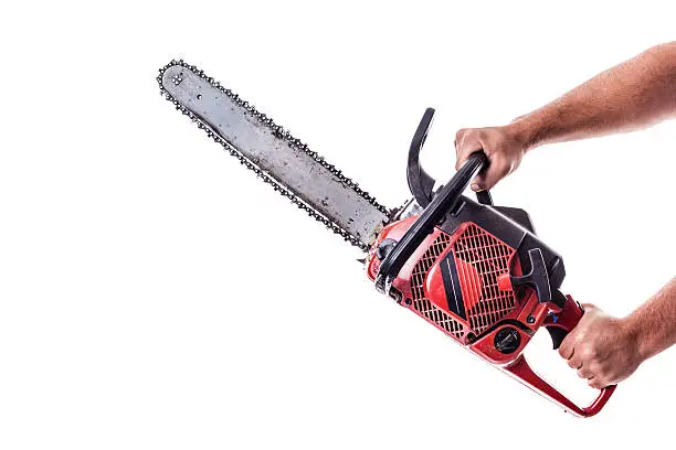 a red chainsaw holded by male arms isolated over white background