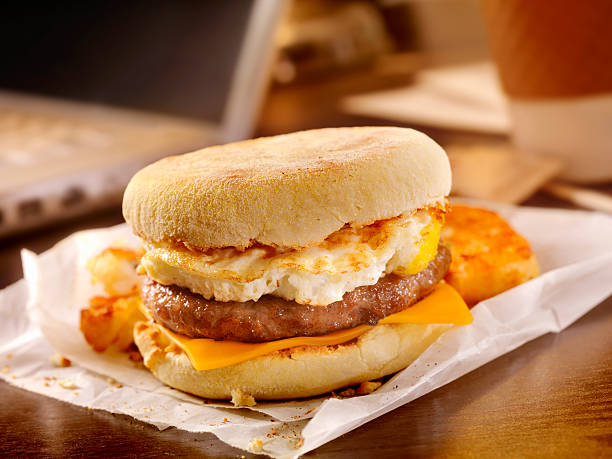 salsicce e uova colazione sandwich alla scrivania - panino ripieno foto e immagini stock
