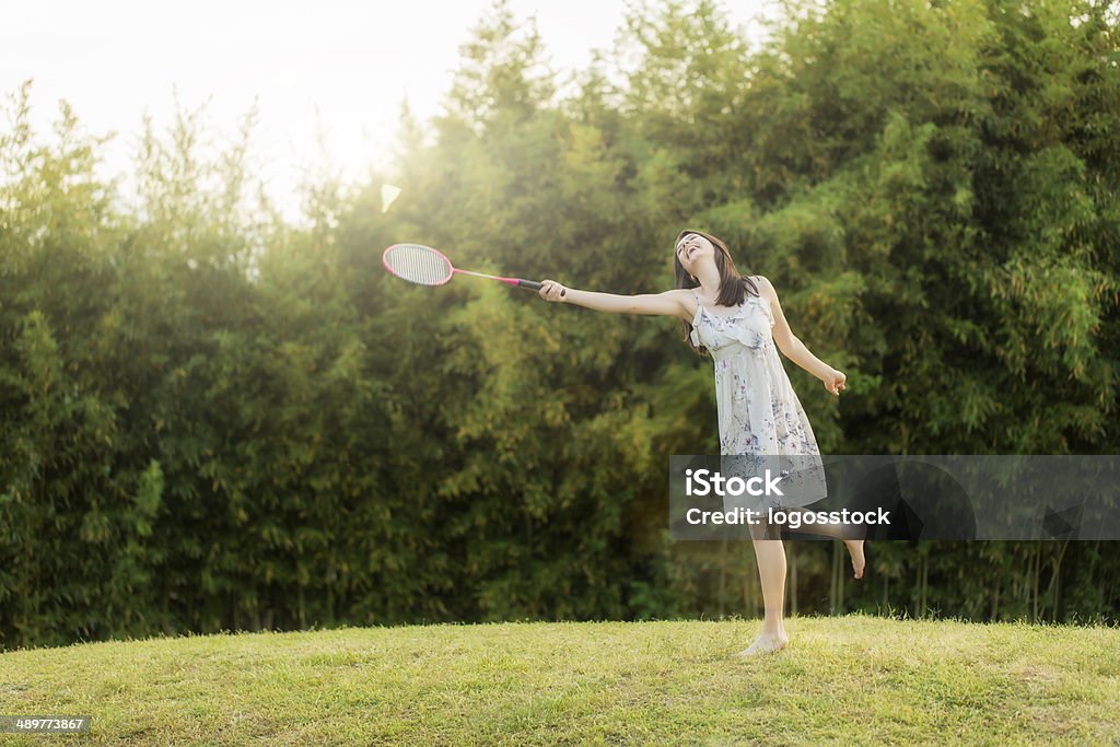 woman plays badminton against summer city park. Active Lifestyle Stock Photo