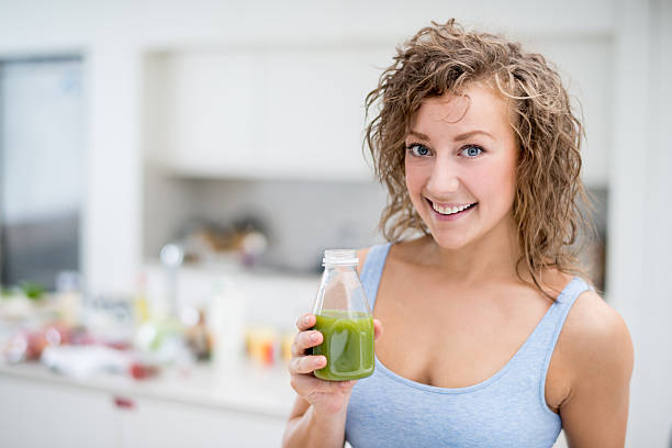 istock Healthy woman drinking a green smoothie 489775884
