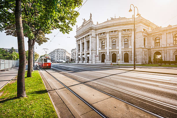 Wiener Ringstrasse with Burgtheater and tram at sunrise, Vienna, Austria Famous Wiener Ringstrasse with historic Burgtheater (Imperial Court Theatre) and traditional red electric tram at sunrise with retro vintage Instagram style filter effect in Vienna, Austria. burgtheater vienna stock pictures, royalty-free photos & images