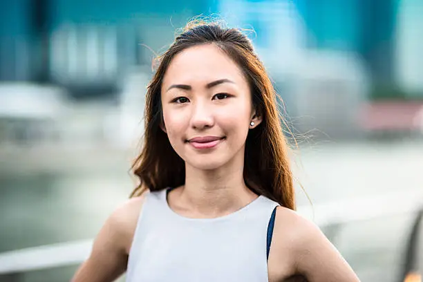 Photo of pretty asian woman standing outdoors