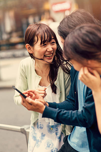 istock Happy japanese friends surfing the net 489776570