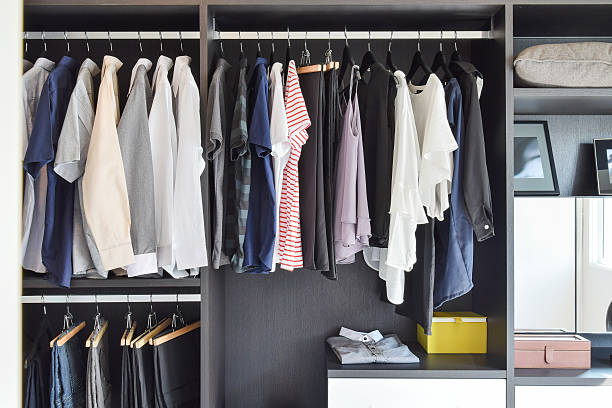 istock modern closet with row of cloths hanging in black wardrobe 489780632