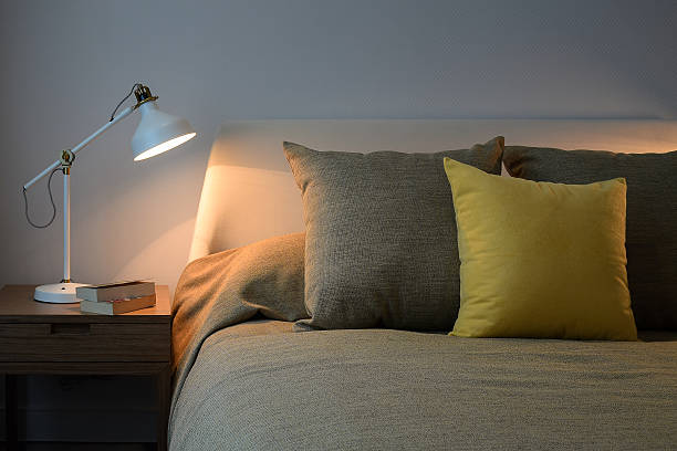 istock Cozy bedroom interior with pillows and reading lamp 489784430