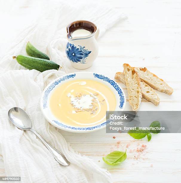 Pumpkin Soup With Cream Fresh Basil Cucumbers And Bread In Stock Photo - Download Image Now