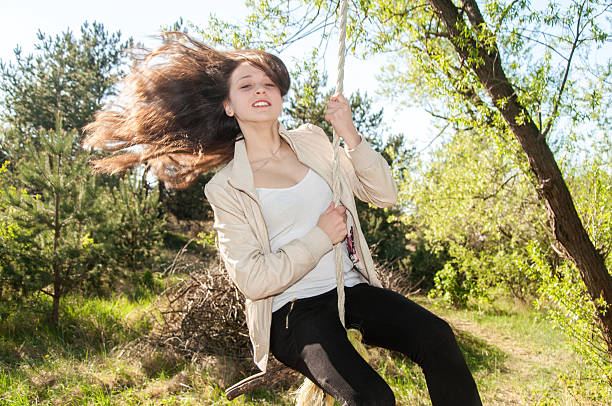 istock Young beautiful girl having fun on a swing 489809595