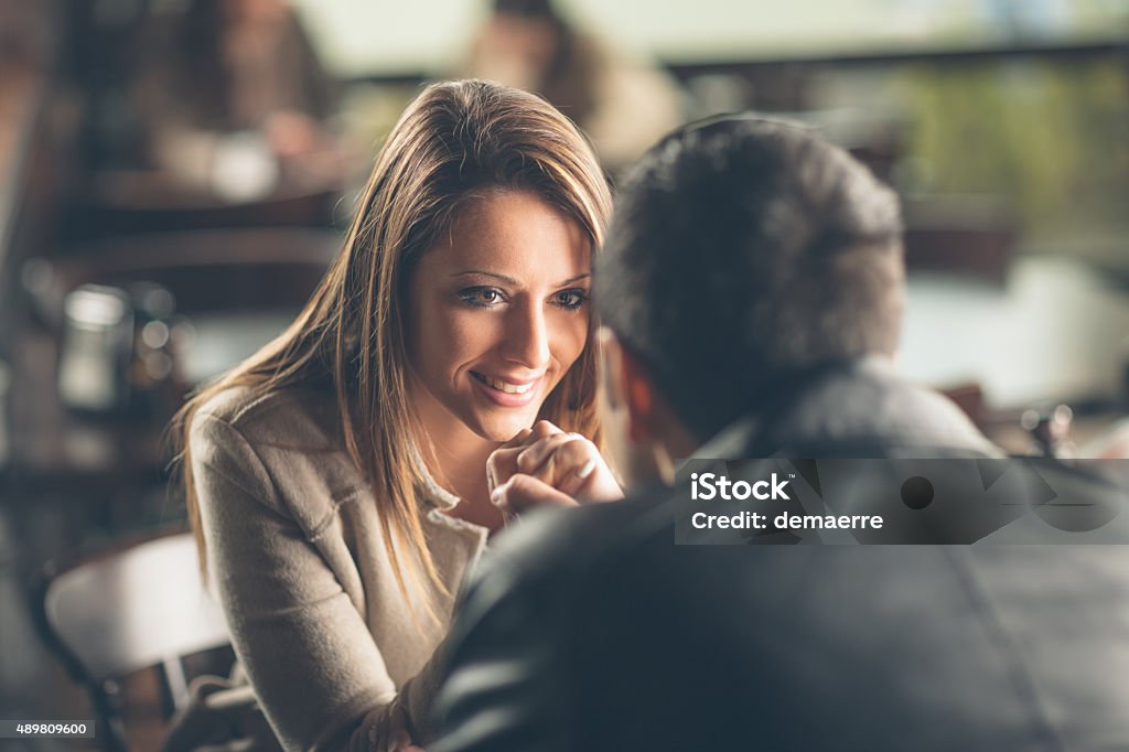 Romantic couple flirting at the bar Romantic young couple dating and flirting at the bar, staring at each other's eyes Flirting Stock Photo