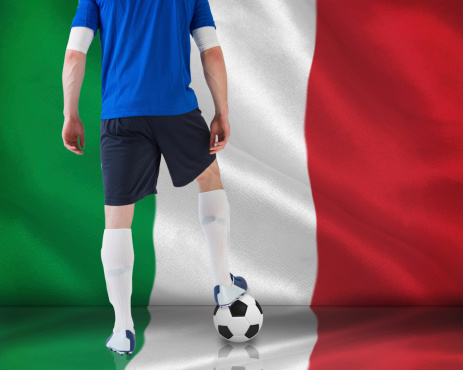 Composite image of football player standing with ball against digitally generated italian national flag