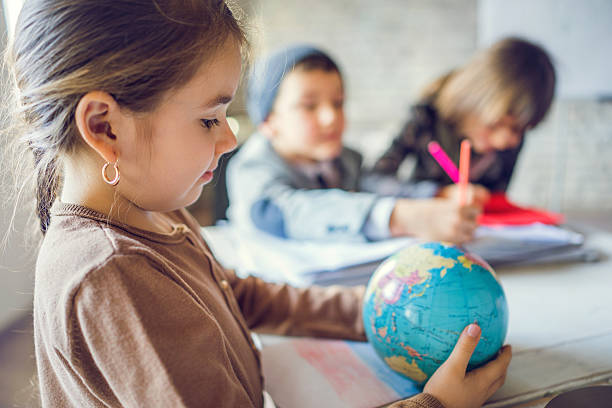 istock Creative little girl studying world globe. 489810276