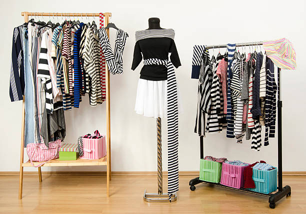 istock Dressing closet with striped clothes arranged on hangers. 489811307