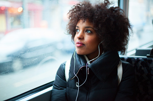 Chica escuchando música en transporte público photo