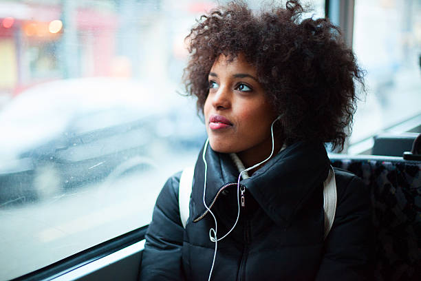 若い女性の音楽を聴いたりする公共交通機関 - bus transportation indoors people ストックフォトと画像