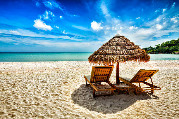 Two lounge chairs under tent on beach Vacation holidays background wallpaper - two beach lounge chairs under tent on beach. Sihanoukville, Cambodia chaise longue photos stock pictures, royalty-free photos & images