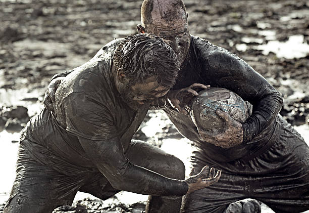 istock Two men fighting for rugby ball in mud 489834378
