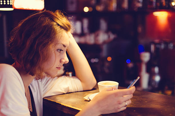Teenage girl using smartphone in a cafe