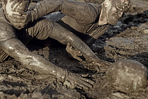 istock Two men fighting for rugby ball in mud 489834874