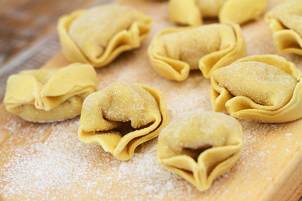 istock Uncooked tortellini on wooden board 489835326